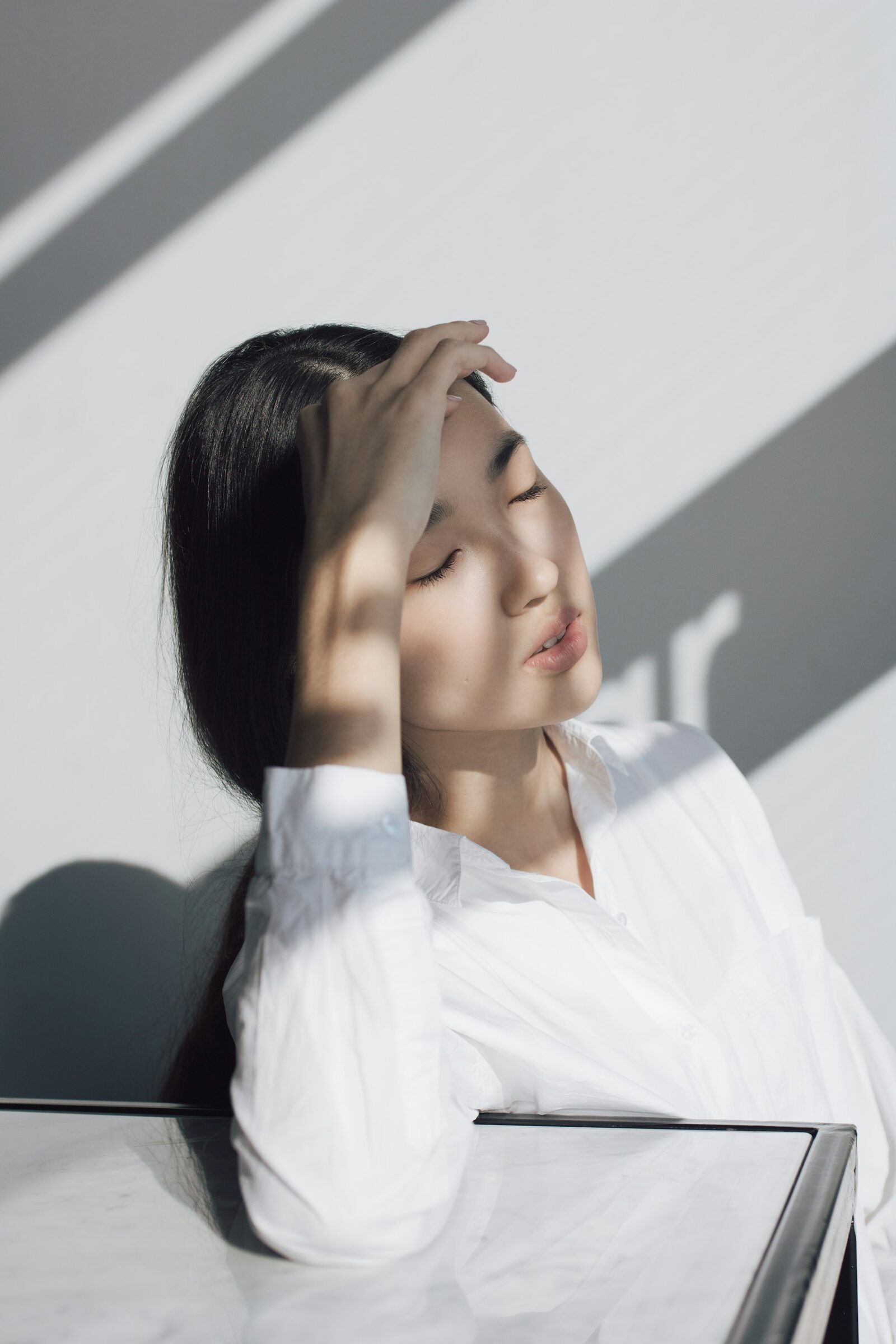 Une femme apaisée, les yeux clos, dans une lumière douce